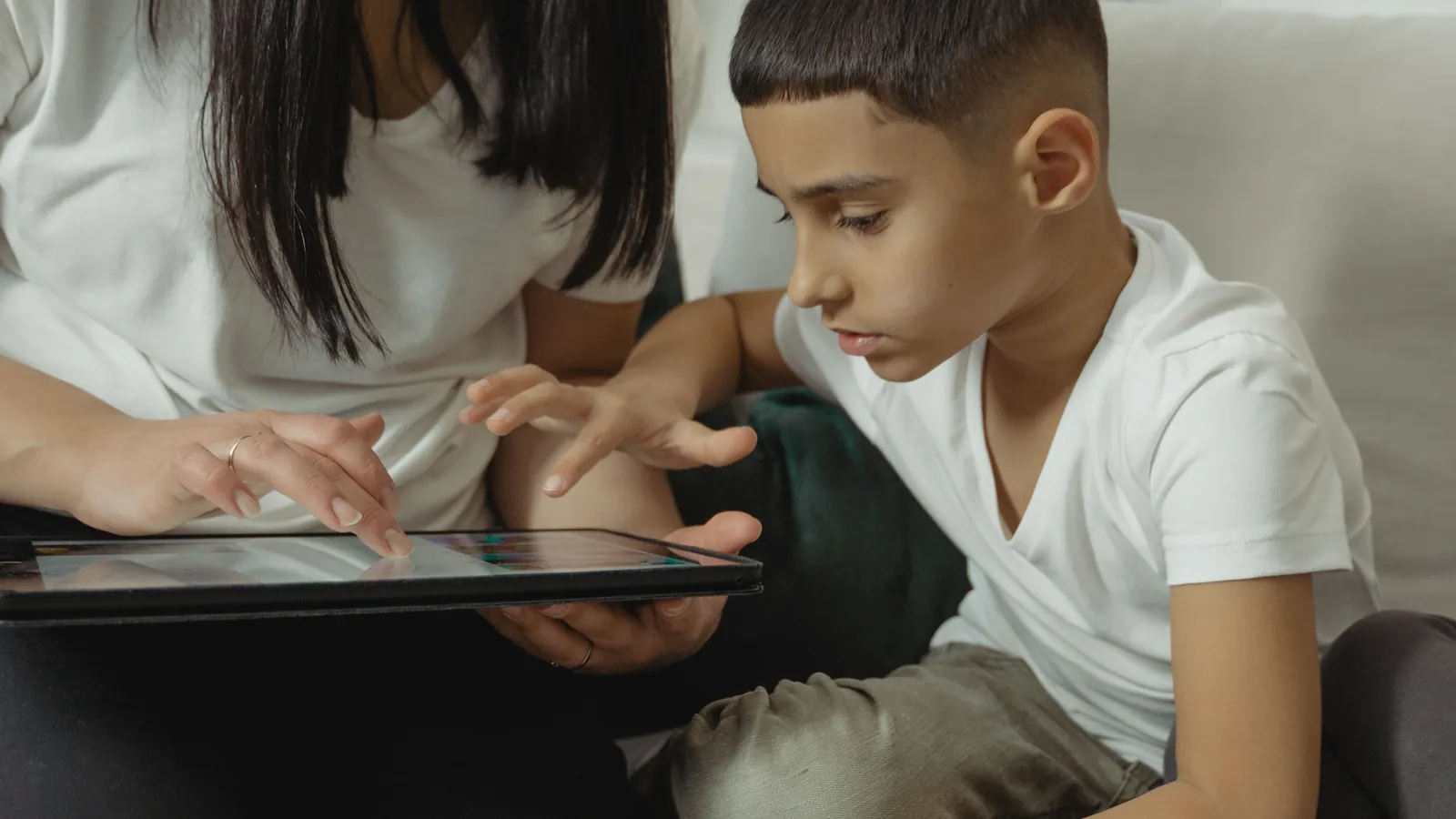 Un parent et un enfant devant une tablette